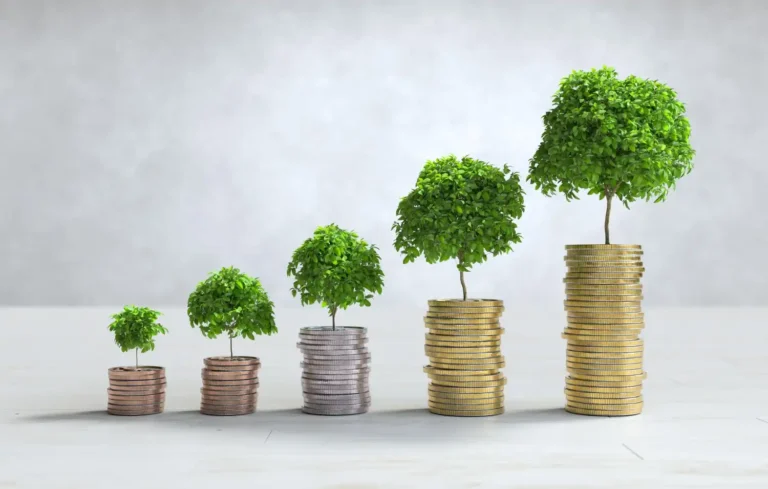 Stacked coins with trees growing on top – eco investment concept